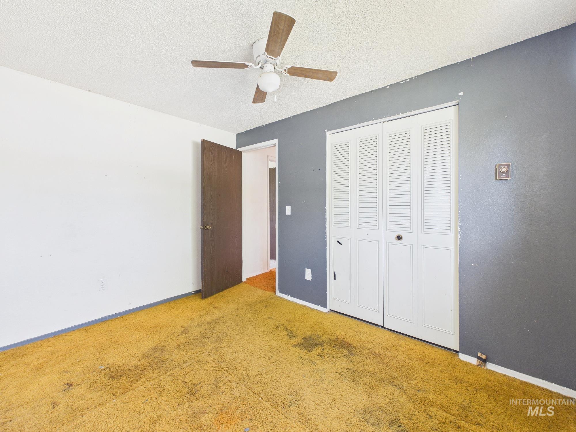 1527 North Plaza Road Emmett, ID 83617 - Photo 15 of 33 Room featuring a ceiling fan with light fixture, bi-fold closet doors, and wood-panel interior door