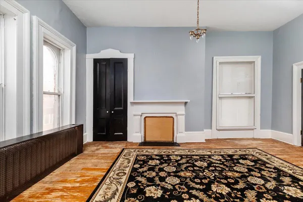 a view of empty room with wooden floor and fireplace