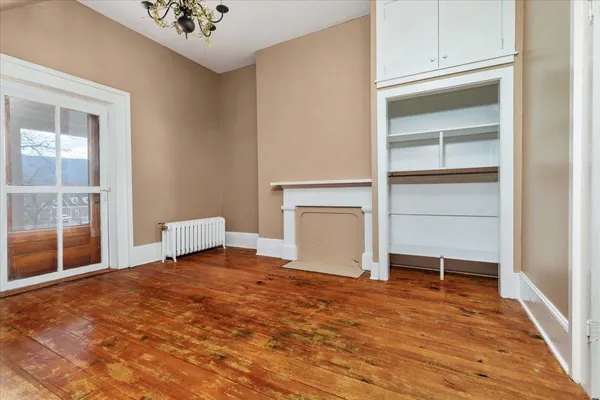 a living room with hard wood floors and kitchen view