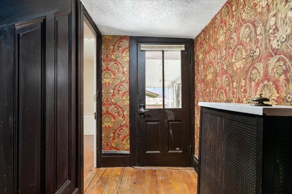 a view of a livingroom with wooden floor and a fireplace