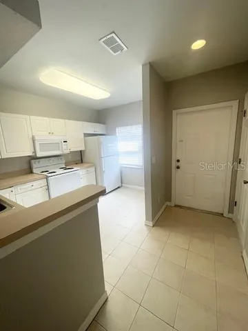 a kitchen with stainless steel appliances a sink a stove a refrigerator a microwave and cabinets