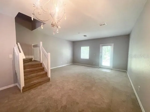 a view of empty room with stairs and wooden floor