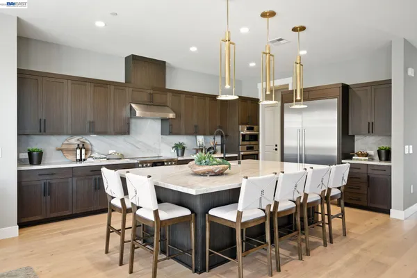 a kitchen with stainless steel appliances granite countertop a sink and a refrigerator