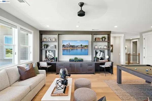 a living room with furniture pool table and a flat screen tv