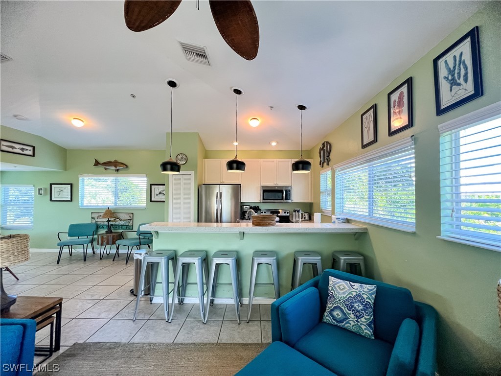 4510 Schooner Drive Upper Captiva, FL 33924 - Photo 26 of 48 a kitchen with stainless steel appliances kitchen island granite countertop a stove a sink a dining table and chairs with wooden floor