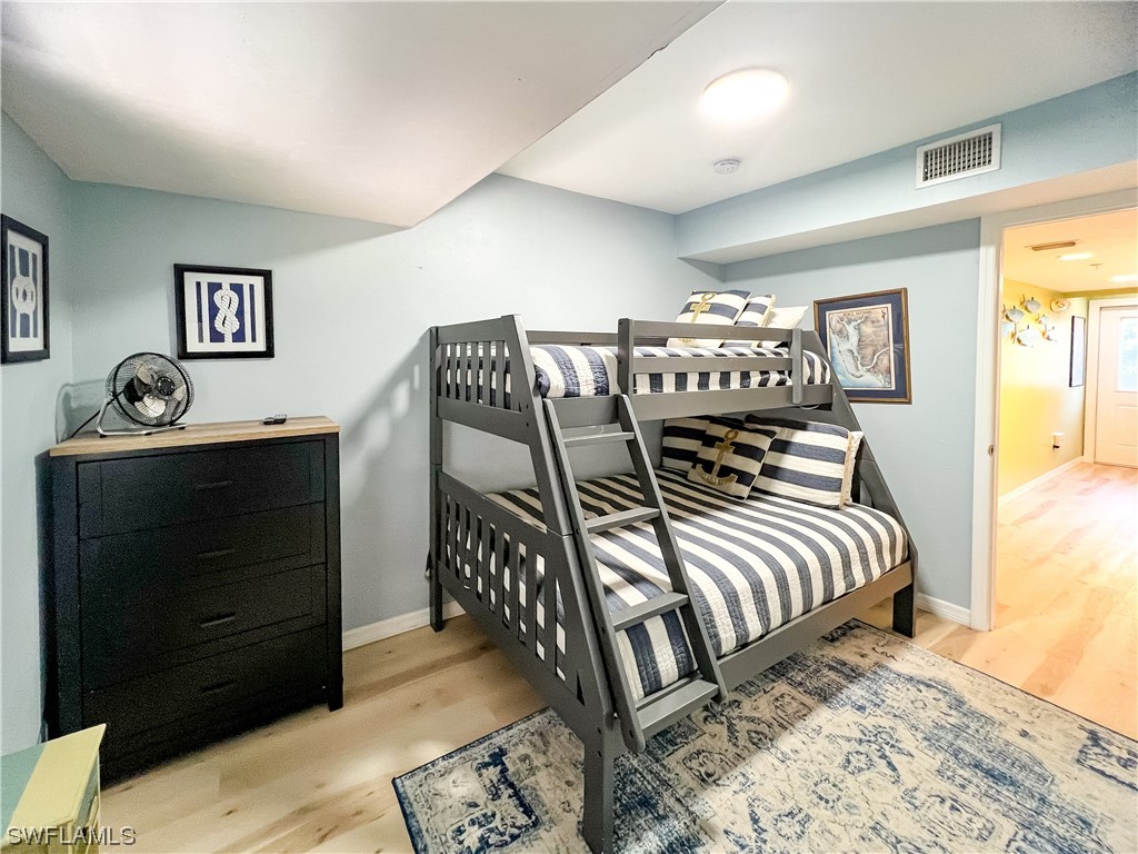 4510 Schooner Drive Upper Captiva, FL 33924 - Photo 29 of 48 a bedroom with a bed and wooden floor