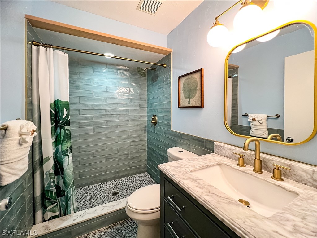 4510 Schooner Drive Upper Captiva, FL 33924 - Photo 33 of 48 a bathroom with a granite countertop sink toilet and shower