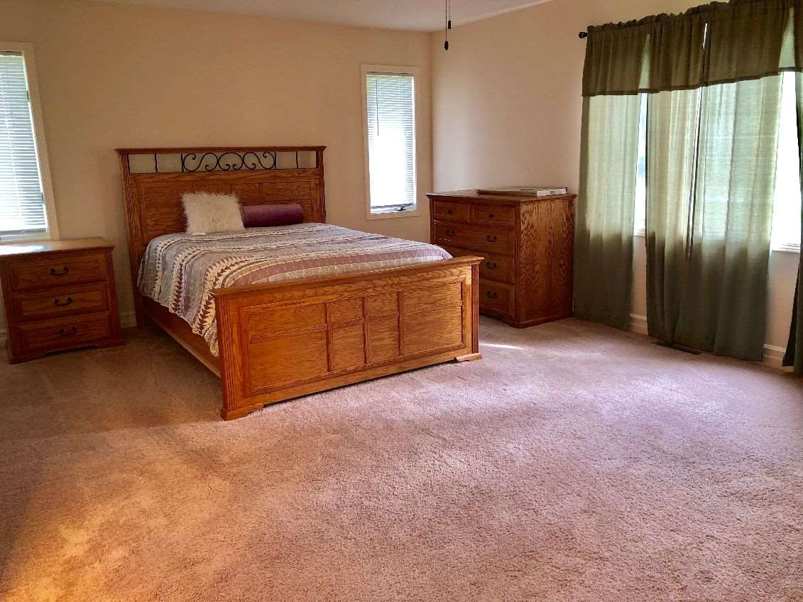 5206 North Woodburn Road Byron, IL 61010 - Photo 8 of 25 a spacious bedroom with a bed and a dresser