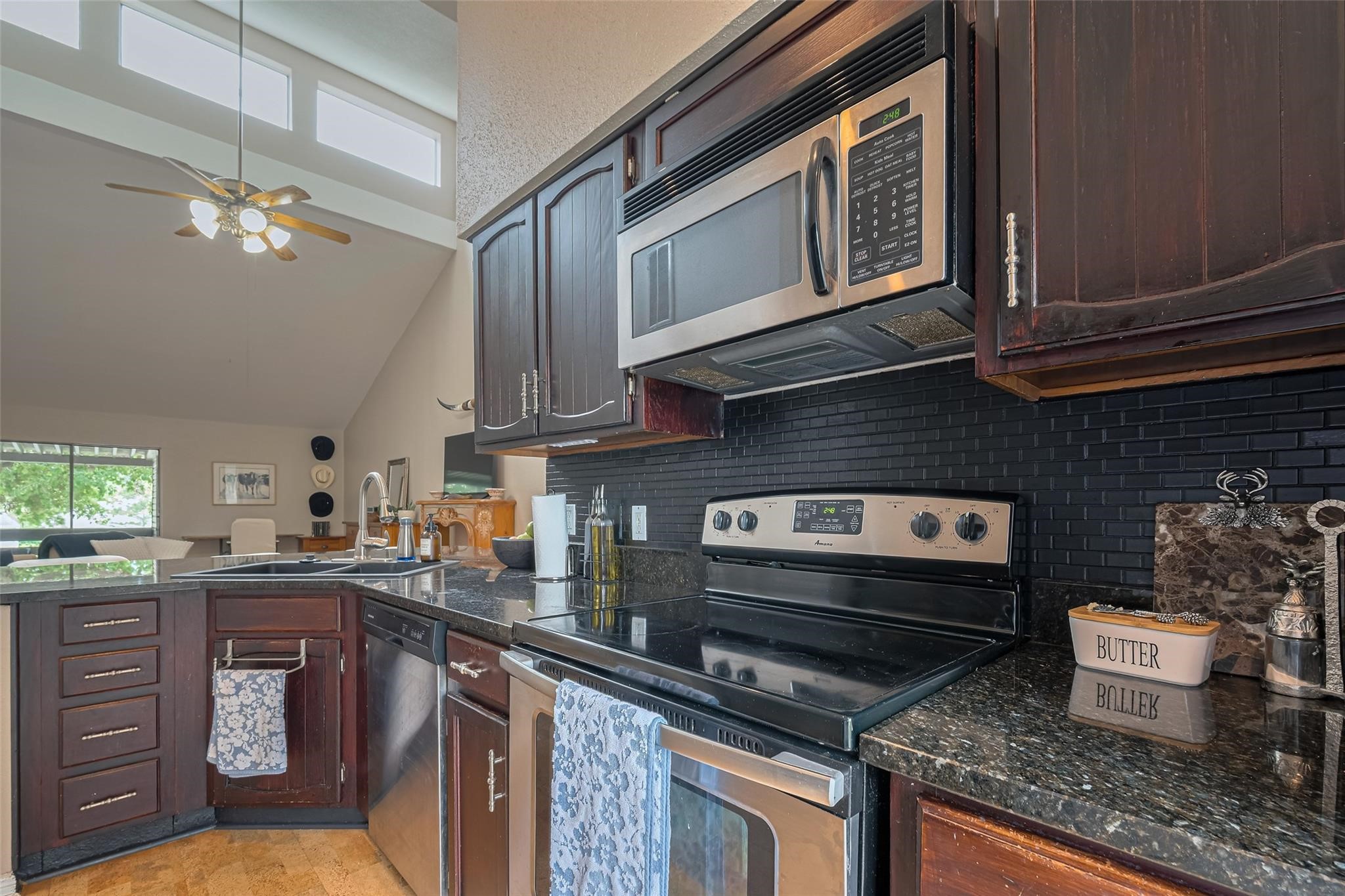 182 April Point Drive North Conroe, TX 77356 - Photo 7 of 18 a kitchen with stainless steel appliances granite countertop a stove a sink and a microwave
