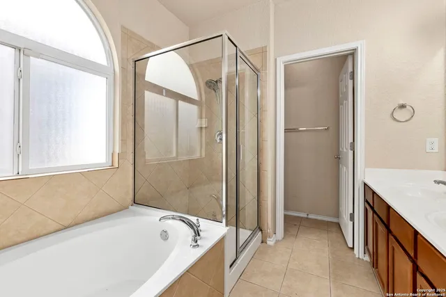 a spacious bathroom with a tub sink and mirror