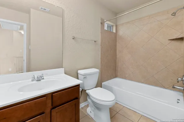 an empty room with windows and ceiling fan