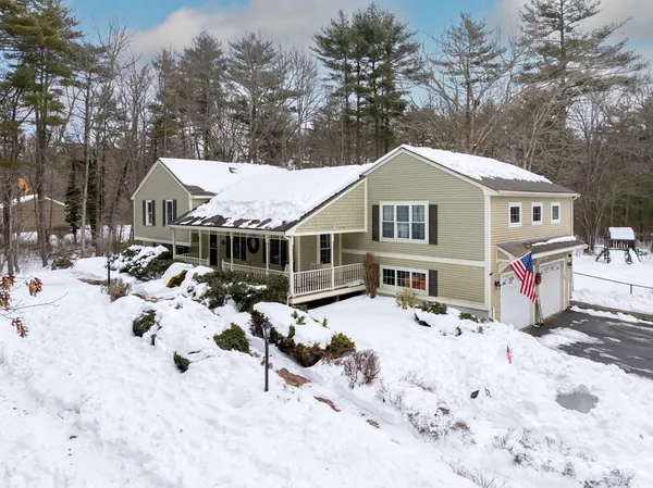 a front view of a house with a yard covered in snow