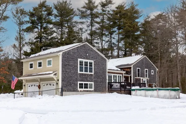 a front view of a house with a yard covered in snow