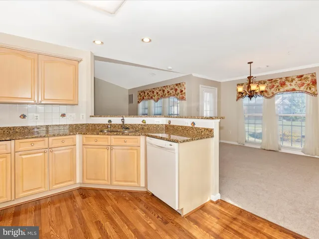 a kitchen with granite countertop a sink and cabinets