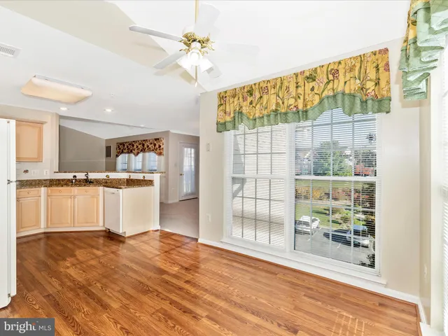 a large white kitchen with kitchen island a stove a wooden floor and a sink