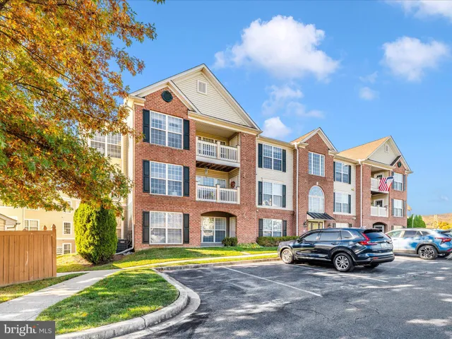 a car parked in front of a brick house next to a yard