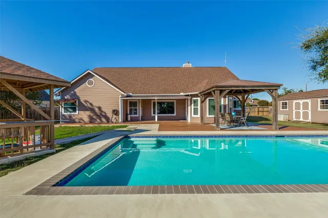 a house with swimming pool in front of it