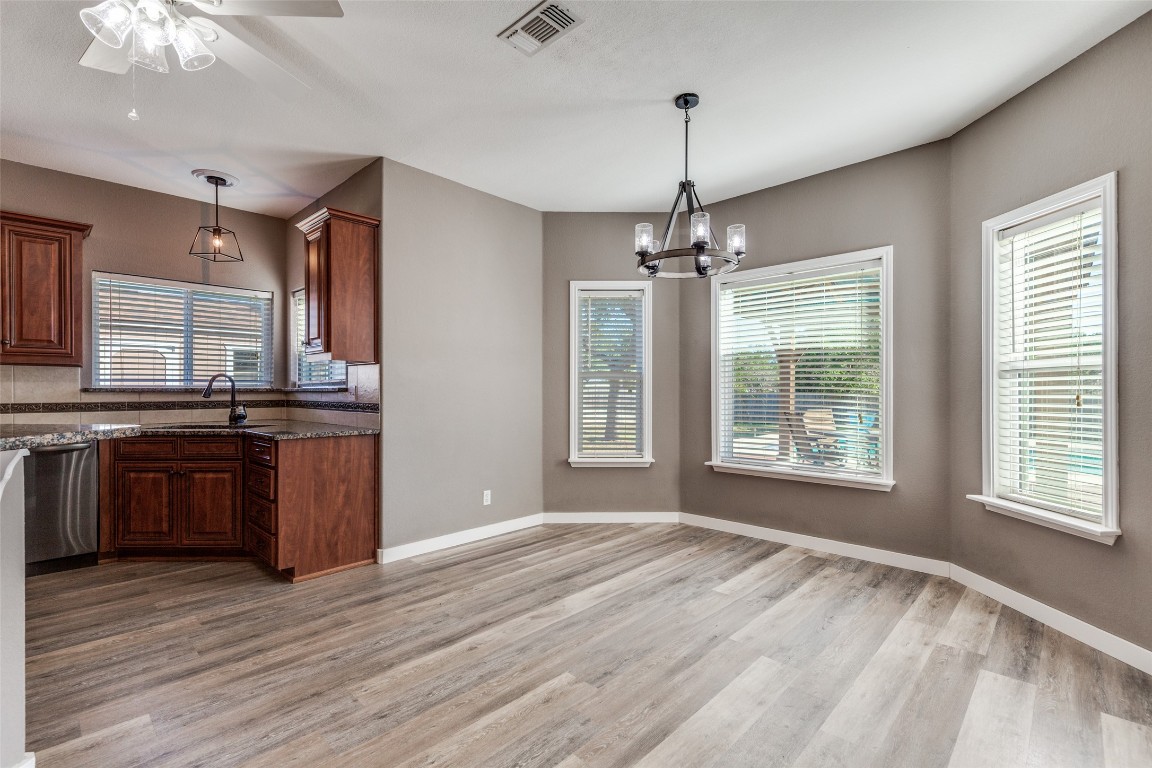 1536 Kings Ranch Road Bandera, TX 78003 - Photo 16 of 35 a open kitchen with stainless steel appliances granite countertop a sink dishwasher a stove and a refrigerator with wooden floor