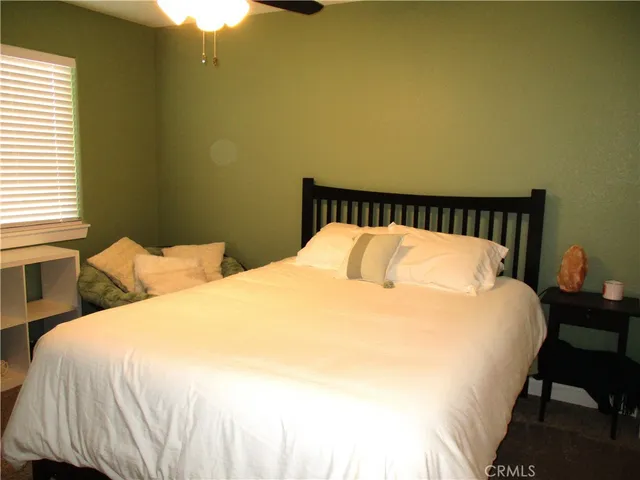 a large bed sitting in a bedroom next to a window