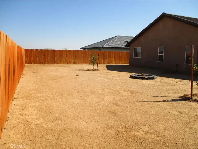 a backyard of a house with glass top table and chairs