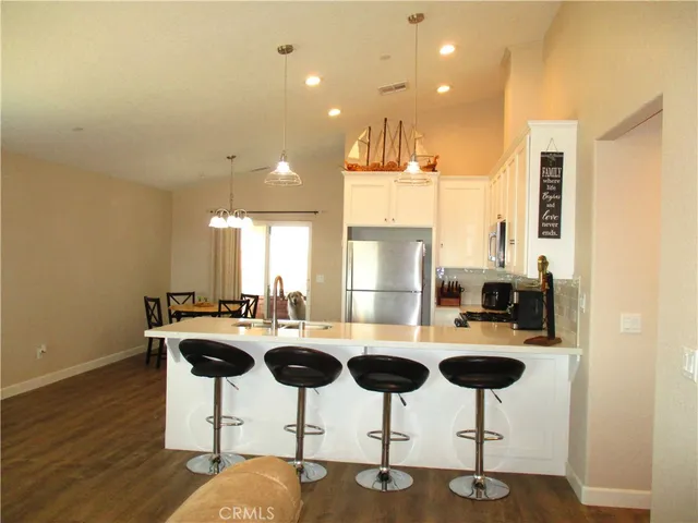 a kitchen with stainless steel appliances kitchen island granite countertop a table and chairs