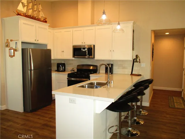 a kitchen with a sink a microwave a refrigerator and cabinets