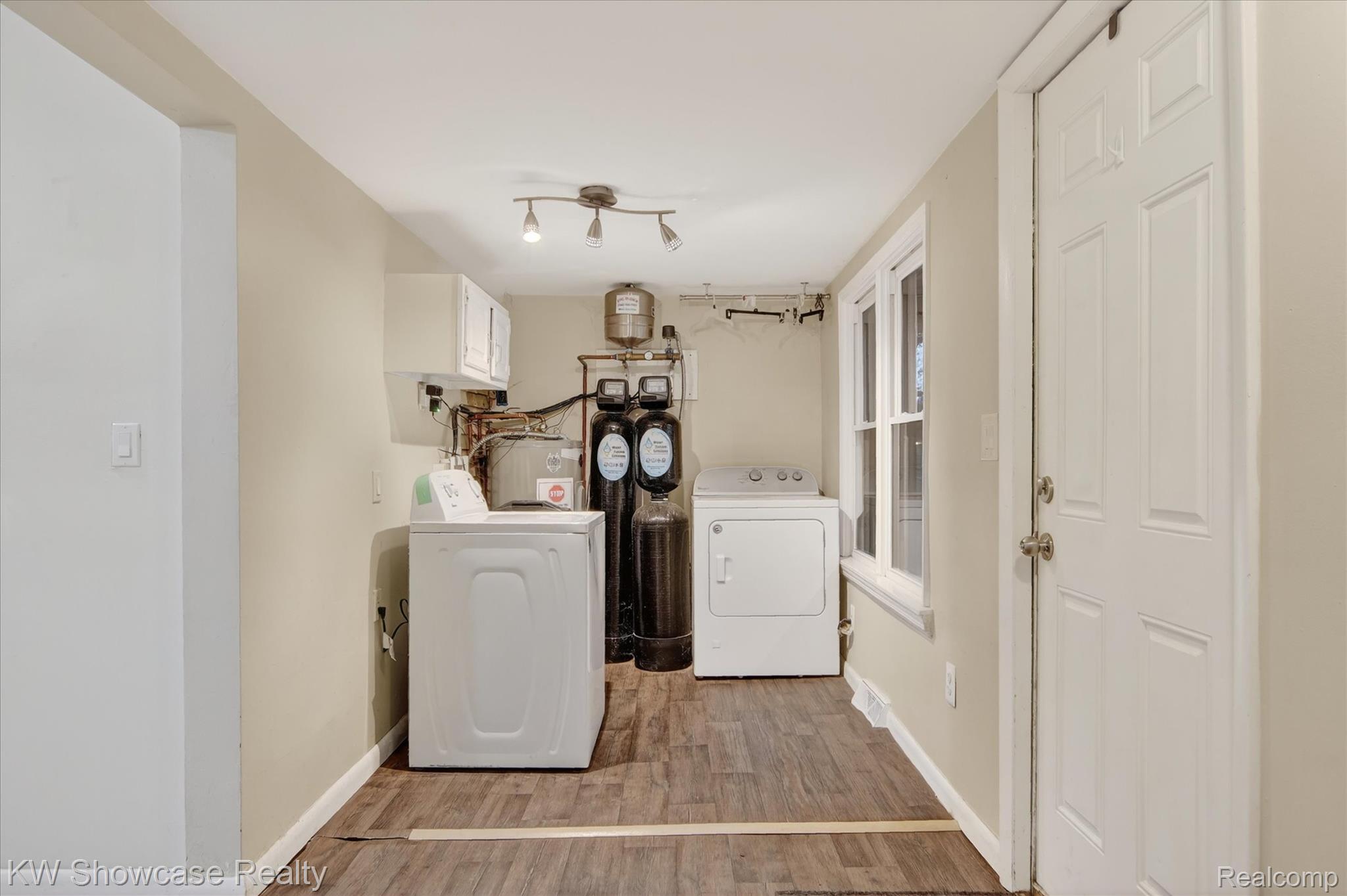 1860 Ladd Road Walled Lake, MI 48390 - Photo 27 of 48 Laundry area with independent washer and dryer, light wood-style floors, and electric water heater