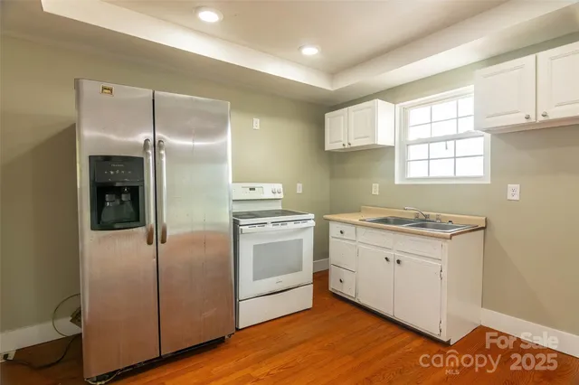 a kitchen with a refrigerator sink and cabinets