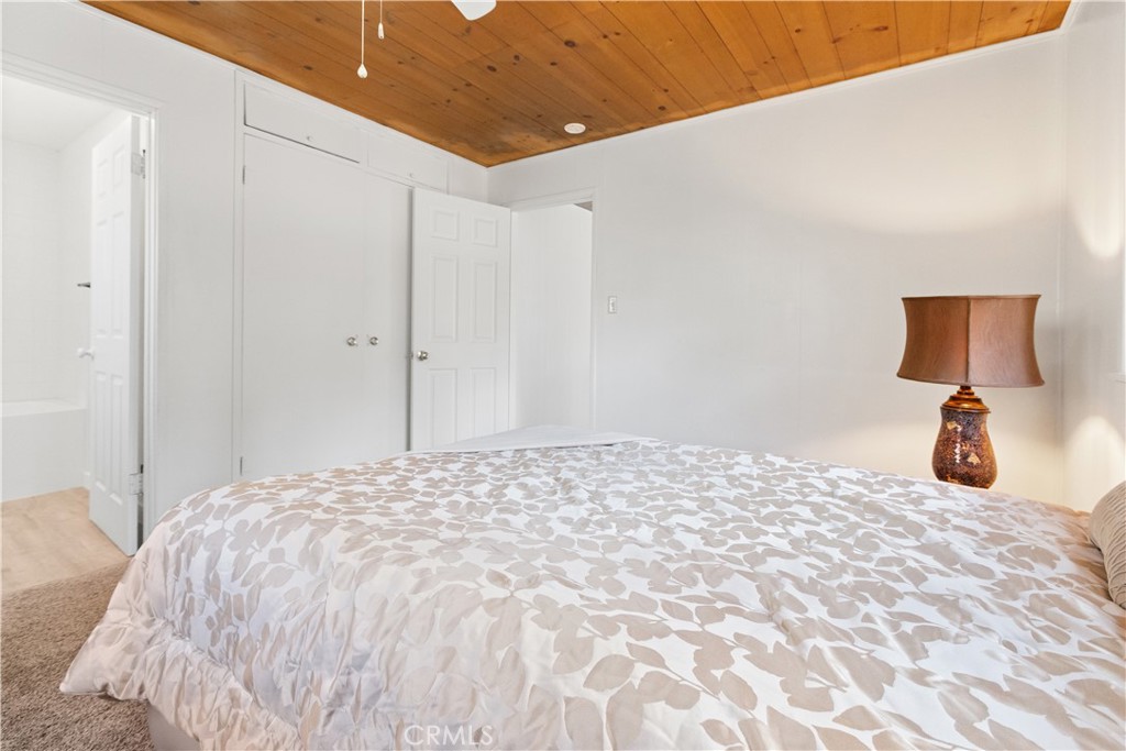 1777 Sparrow Road Wrightwood, CA 92397 - Photo 11 of 44 a bedroom with a bed and a large mirror