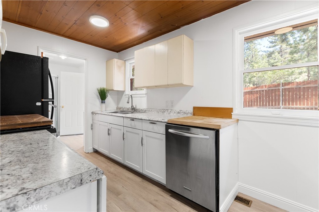 1777 Sparrow Road Wrightwood, CA 92397 - Photo 16 of 44 a kitchen with stainless steel appliances granite countertop a sink stove and refrigerator