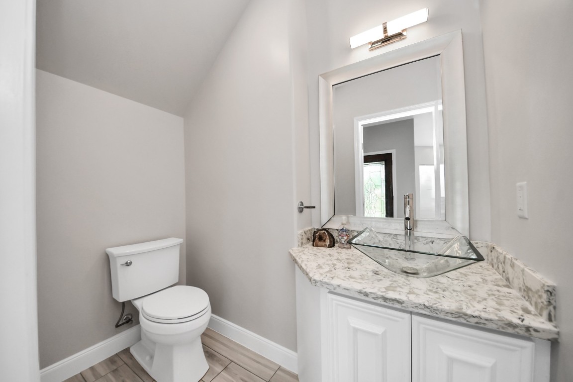 2608 Bostic Street Houston, TX 77093 - Photo 19 of 37 a bathroom with a granite countertop sink a toilet and a mirror