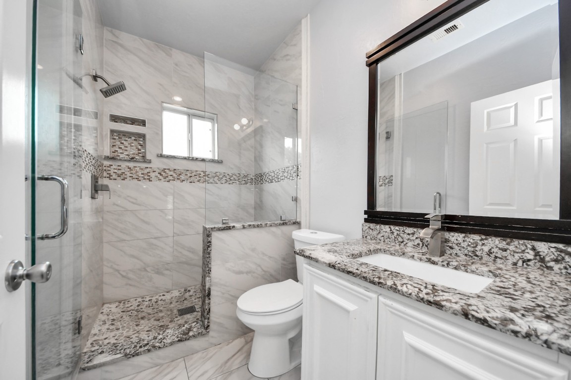 2608 Bostic Street Houston, TX 77093 - Photo 35 of 37 a bathroom with a granite countertop sink a toilet and shower