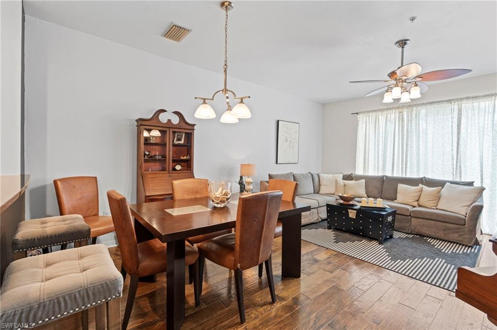 941 Hampton Circle, Unit 109 Naples, FL 34105 - Photo 11 of 27 a living room with furniture a chandelier and a dining table