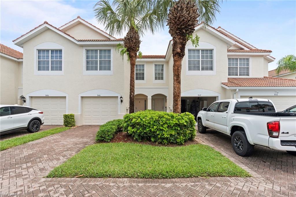 941 Hampton Circle, Unit 109 Naples, FL 34105 - Photo 2 of 27 a front view of a house with a garden and parking