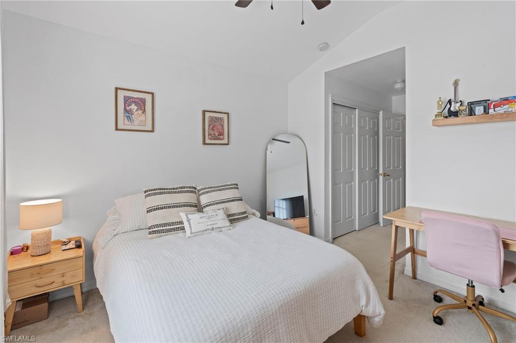 941 Hampton Circle, Unit 109 Naples, FL 34105 - Photo 21 of 27 a bedroom with a bed and a table in it