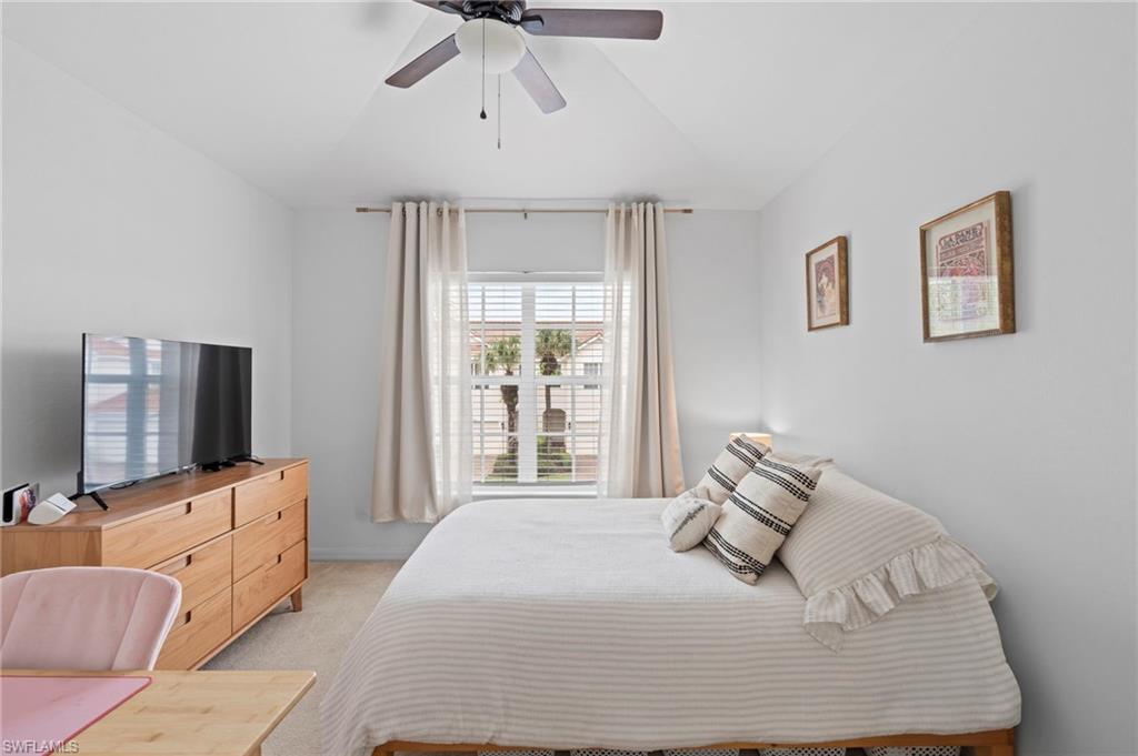 941 Hampton Circle, Unit 109 Naples, FL 34105 - Photo 24 of 27 a bedroom with a bed and flat tv screen