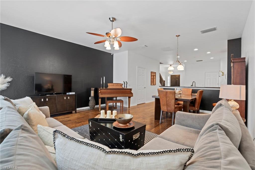 941 Hampton Circle, Unit 109 Naples, FL 34105 - Photo 27 of 27 a living room with furniture a flat screen tv and kitchen view
