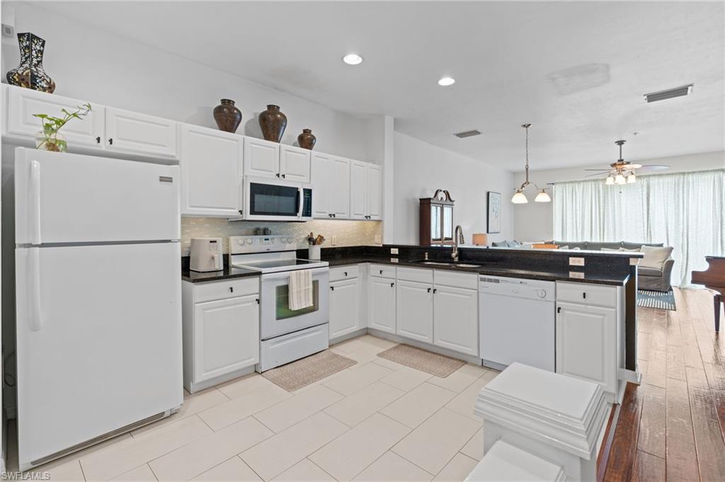 941 Hampton Circle, Unit 109 Naples, FL 34105 - Photo 4 of 27 a kitchen with a refrigerator and a stove top oven