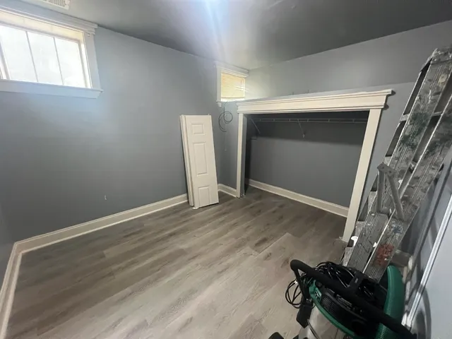 an empty room with wooden floor and fireplace