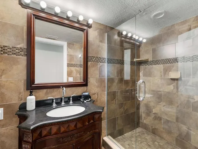a bathroom with a double vanity sink mirror and shower