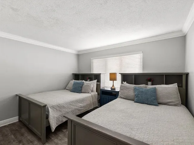 a bedroom with two beds and a night stand