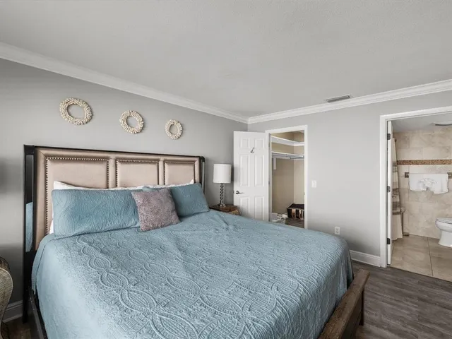 a bedroom with a large bed and wooden floor