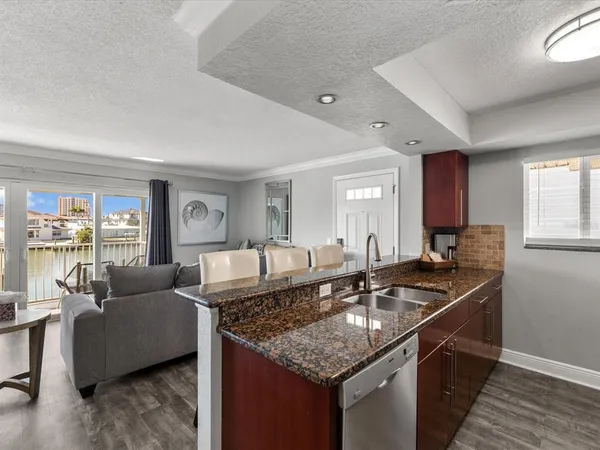 a kitchen with granite countertop a sink and a stove