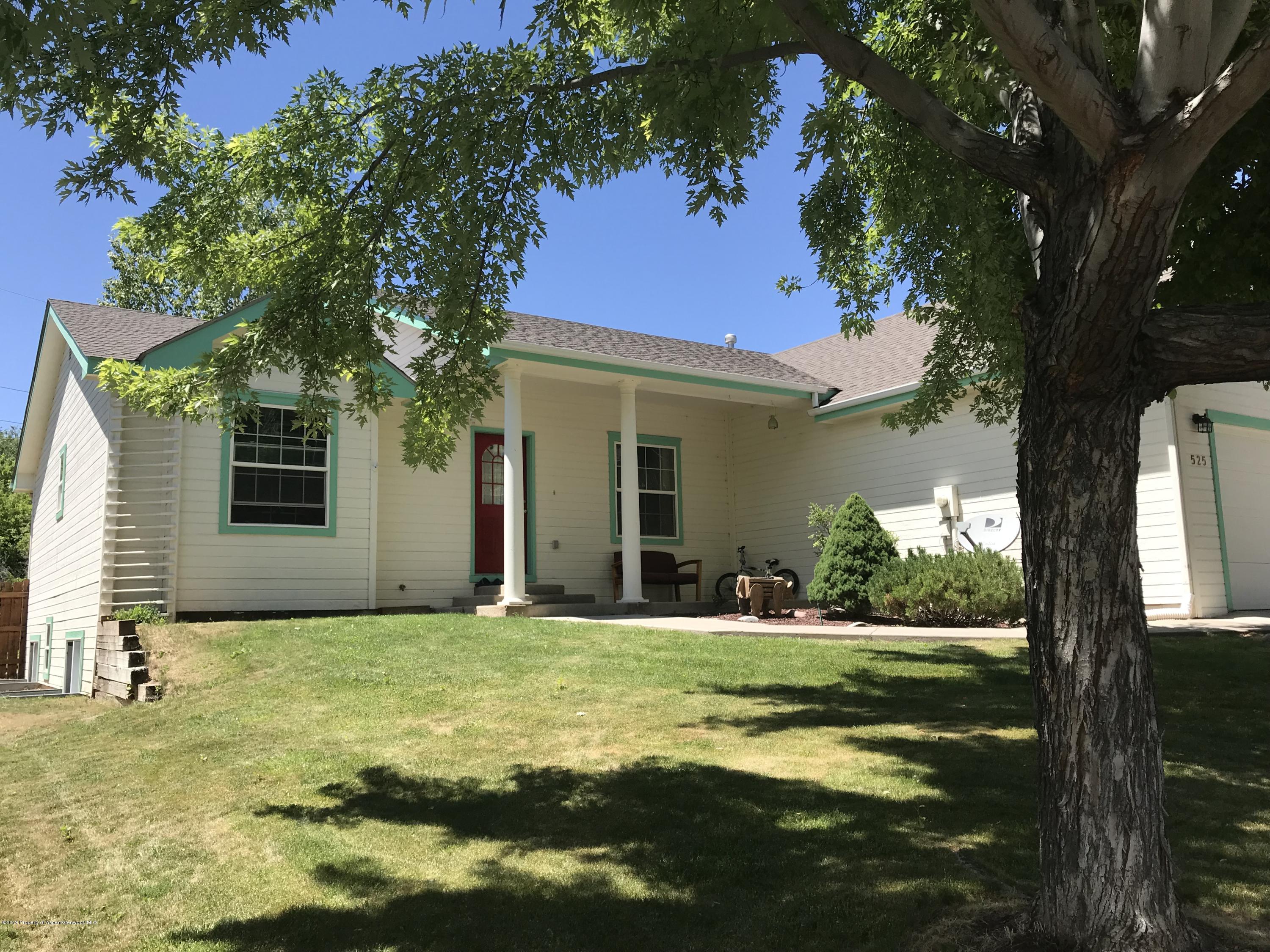 525 Birch Court Rifle, CO 81650 - Photo 1 of 17 a view of a house with a yard and garage