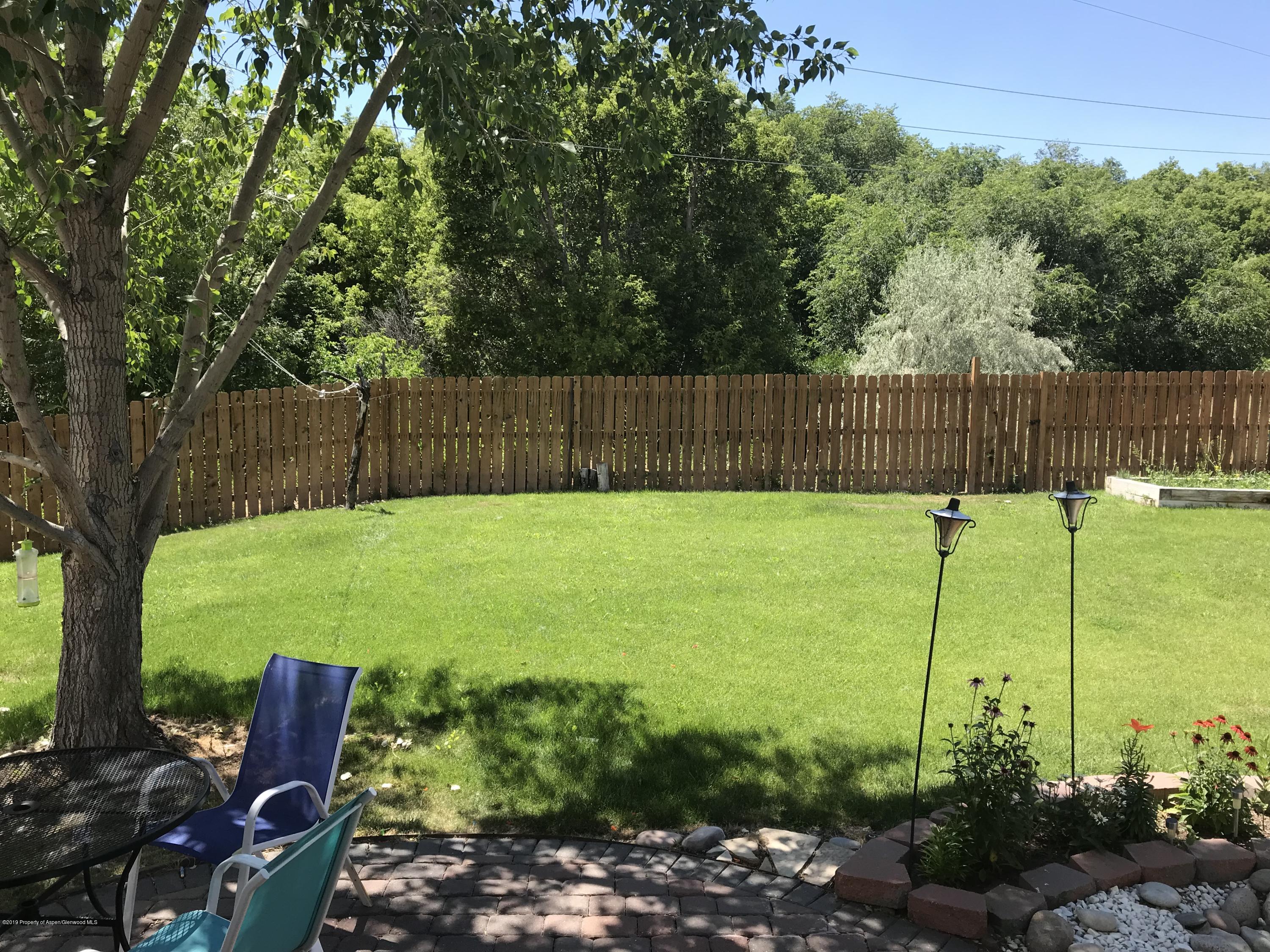 525 Birch Court Rifle, CO 81650 - Photo 16 of 17 a view of a backyard with plants and large trees