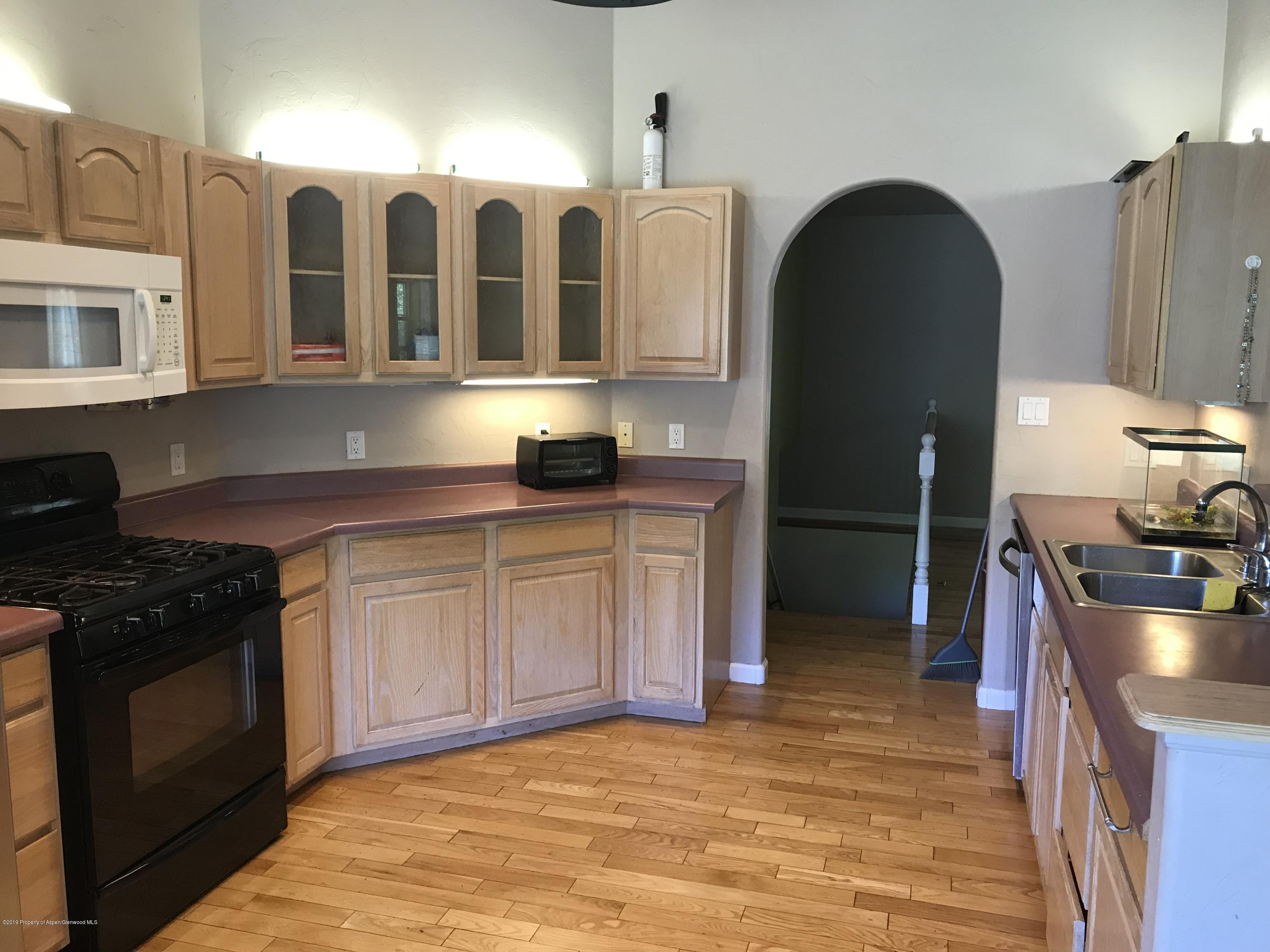 525 Birch Court Rifle, CO 81650 - Photo 6 of 17 a kitchen with stainless steel appliances granite countertop a stove a sink and a microwave