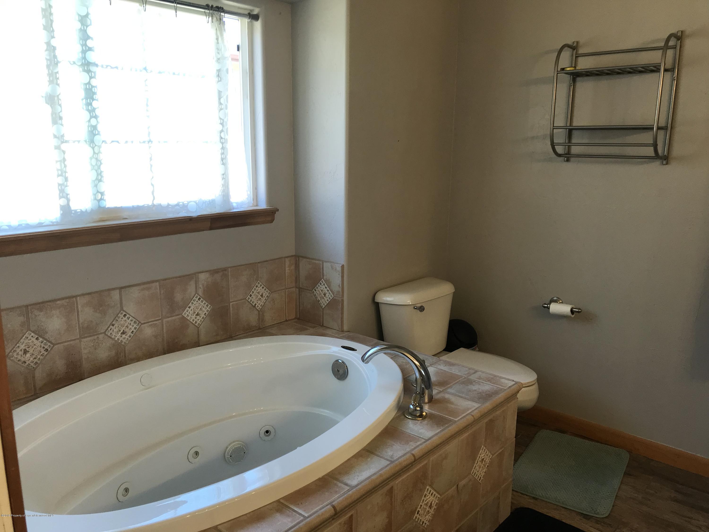 525 Birch Court Rifle, CO 81650 - Photo 9 of 17 a bathroom with a tub and a window