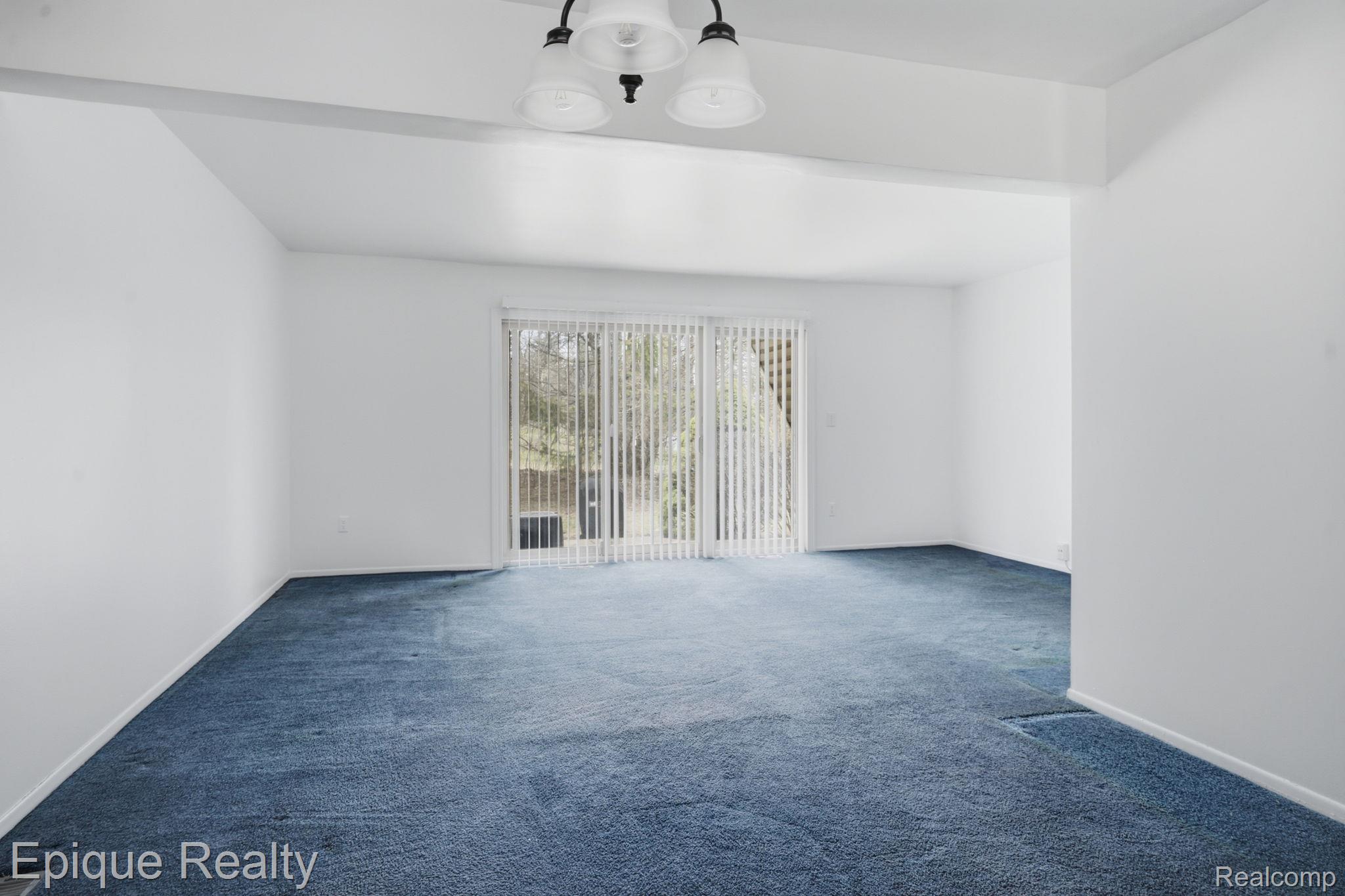 3895 Old Creek Road Troy, MI 48084 - Photo 2 of 23 Carpeted empty room with baseboards and a chandelier