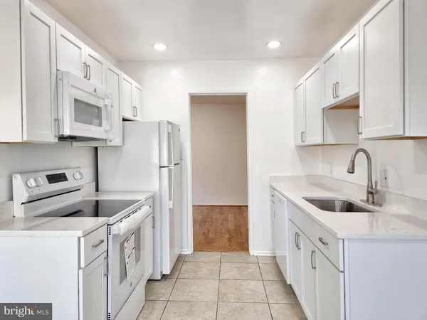 a kitchen with white cabinets and a sink
