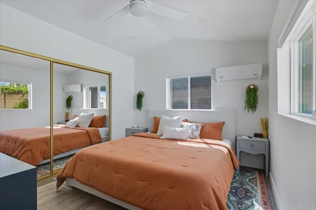 a bedroom with two beds and a large window